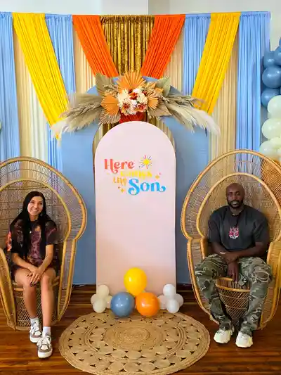 Keirstan and Keante Rodriguez seated at a colorful event setup